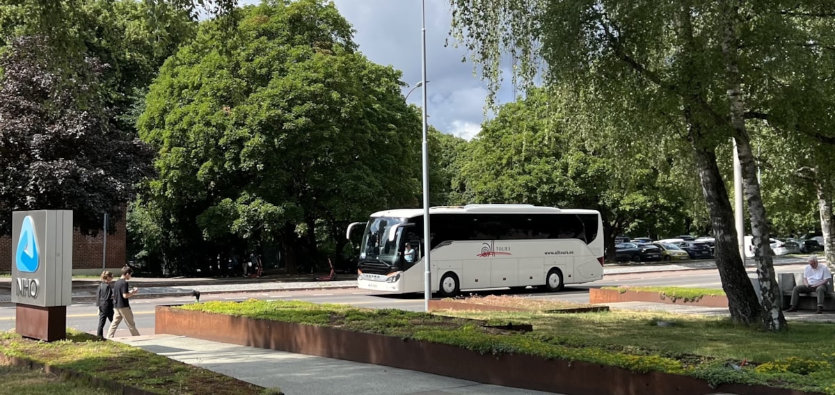 Bildet viser en buss med trær i bakgrunnen