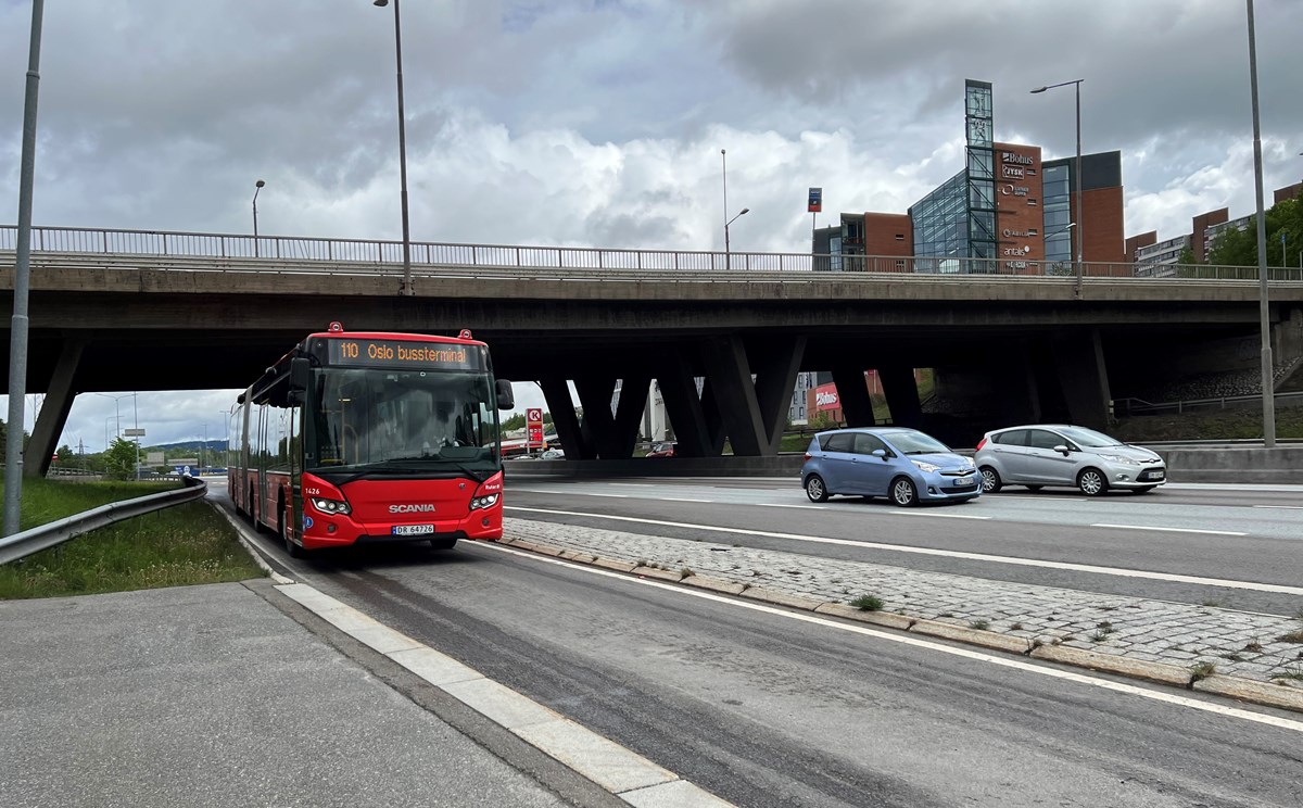 Bildet viser en vei med buss og biler