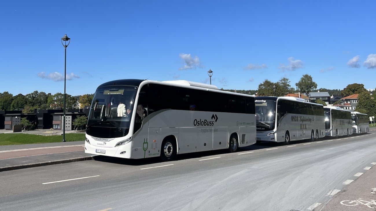 Bildet viser fire turbusser parkert