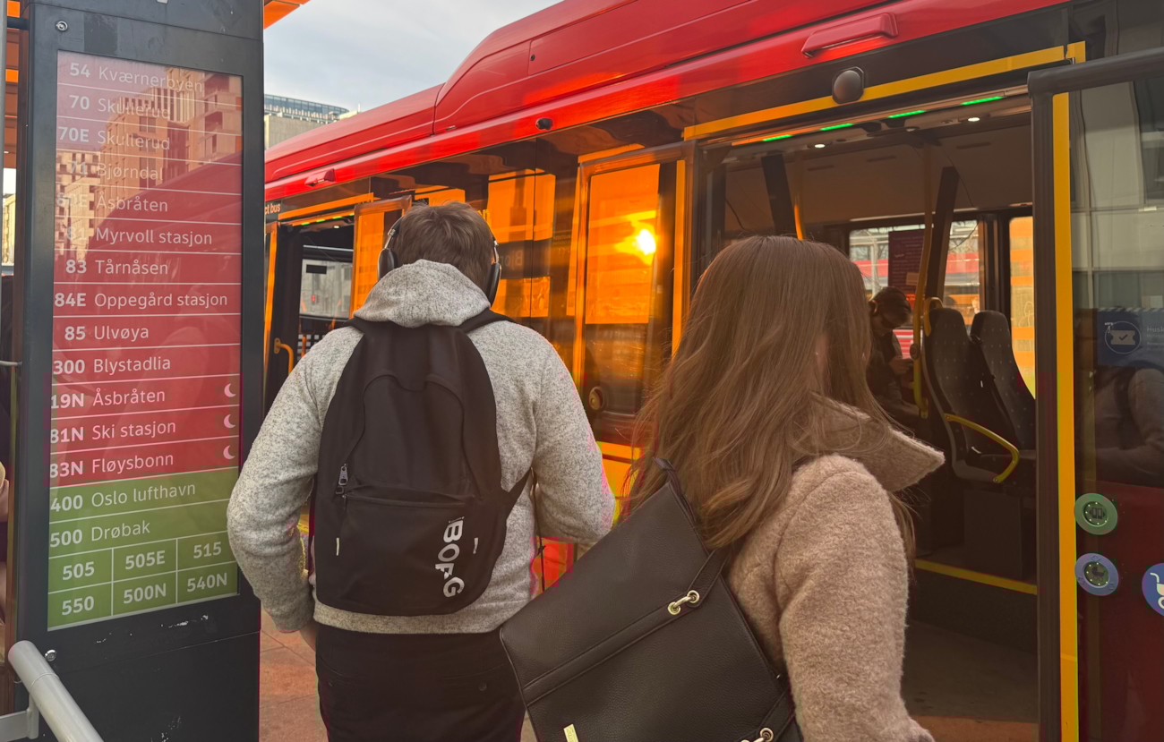 To passasjerer på vei inn i en rutebuss